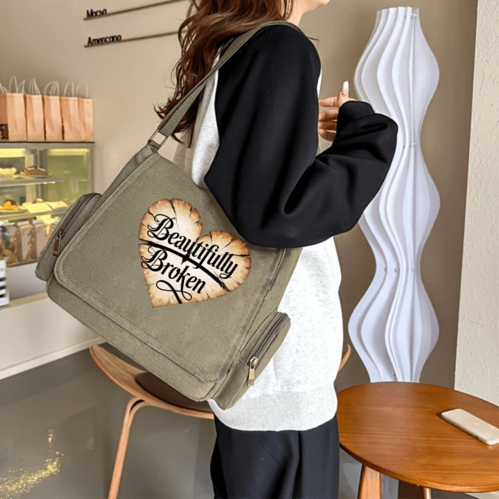 A Spacious Ladies' Shoulder Bag with a Flip-Top Design, Featuring a Vintage Style And a Heart-Shaped Crack Pattern Adorned with The Phrase 'Beautifully Broken'. It'S Perfect for Everyday Use And Travel