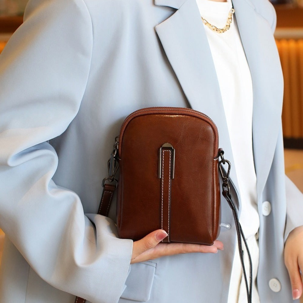A Crossbody Bag Made of Authentic Leather for Women, Featuring a Small Size, an Adjustable Chain Strap, a Zip Closure, And a Stylish Look. Perfect for Both Everyday Use And Formal Events, Offered in Shades of Coffee Brown, Beige, And Black