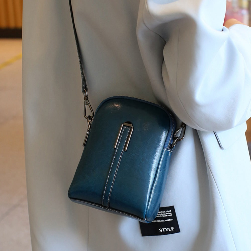 A Crossbody Bag Made of Authentic Leather for Women, Featuring a Small Size, an Adjustable Chain Strap, a Zip Closure, And a Stylish Look. Perfect for Both Everyday Use And Formal Events, Offered in Shades of Coffee Brown, Beige, And Black